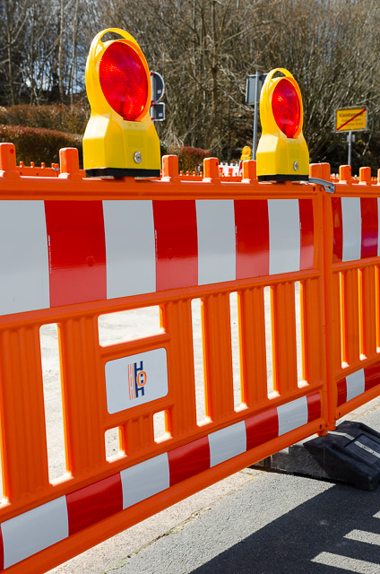 Bild mit Verkehssicherungs-Barken. Bedruckt mit orange-blauem Logo