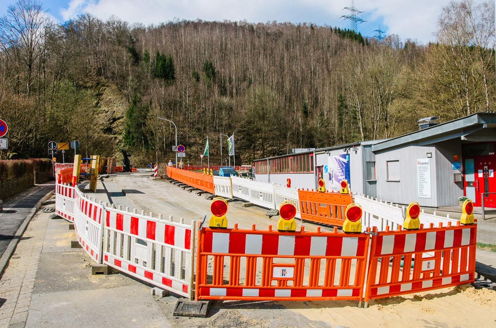 Baustelle mit orangenen Absicherungselementen und roten Leuchten zur Verkehrssicherung im Baustellenbereich.