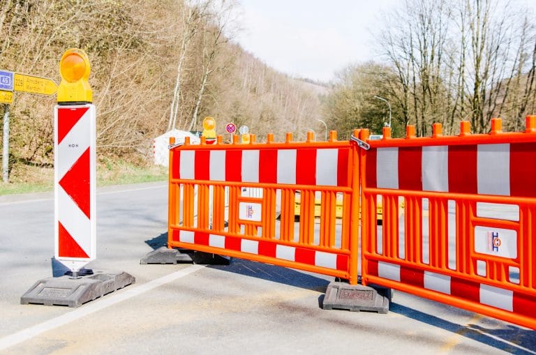 Baustellenzaun in orange und Verkehrsleitkegel vor Baustelle